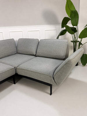 Gebrauchtes graues Rolf Benz Mera Designer Stoff Sofa vor einer Wand, stilvoll und modern eingerichtet.