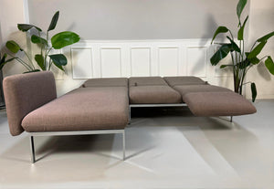 Gebrauchtes graues Brühl Roro Designer Stoff Ecksofa vor einer Wand, stilvoll und modern eingerichtet.