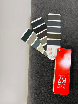 Ausstellungsstück Brühl Moule Designer Stoff Sofa in Grau vor einer Wand, stilvoll und modern eingerichtet.