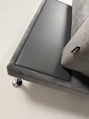 Ausstellungsstück Brühl Moule Designer Stoff Sofa in Grau vor einer Wand, stilvoll und modern eingerichtet.