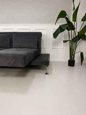 Ausstellungsstück Brühl Moule Designer Stoff Sofa in Grau vor einer Wand, stilvoll und modern eingerichtet.
