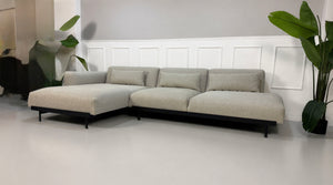 Gebrauchtes grau beiges Muuto In Situ Designer Stoff Sofa vor einer Wand, stilvoll und modern eingerichtet.