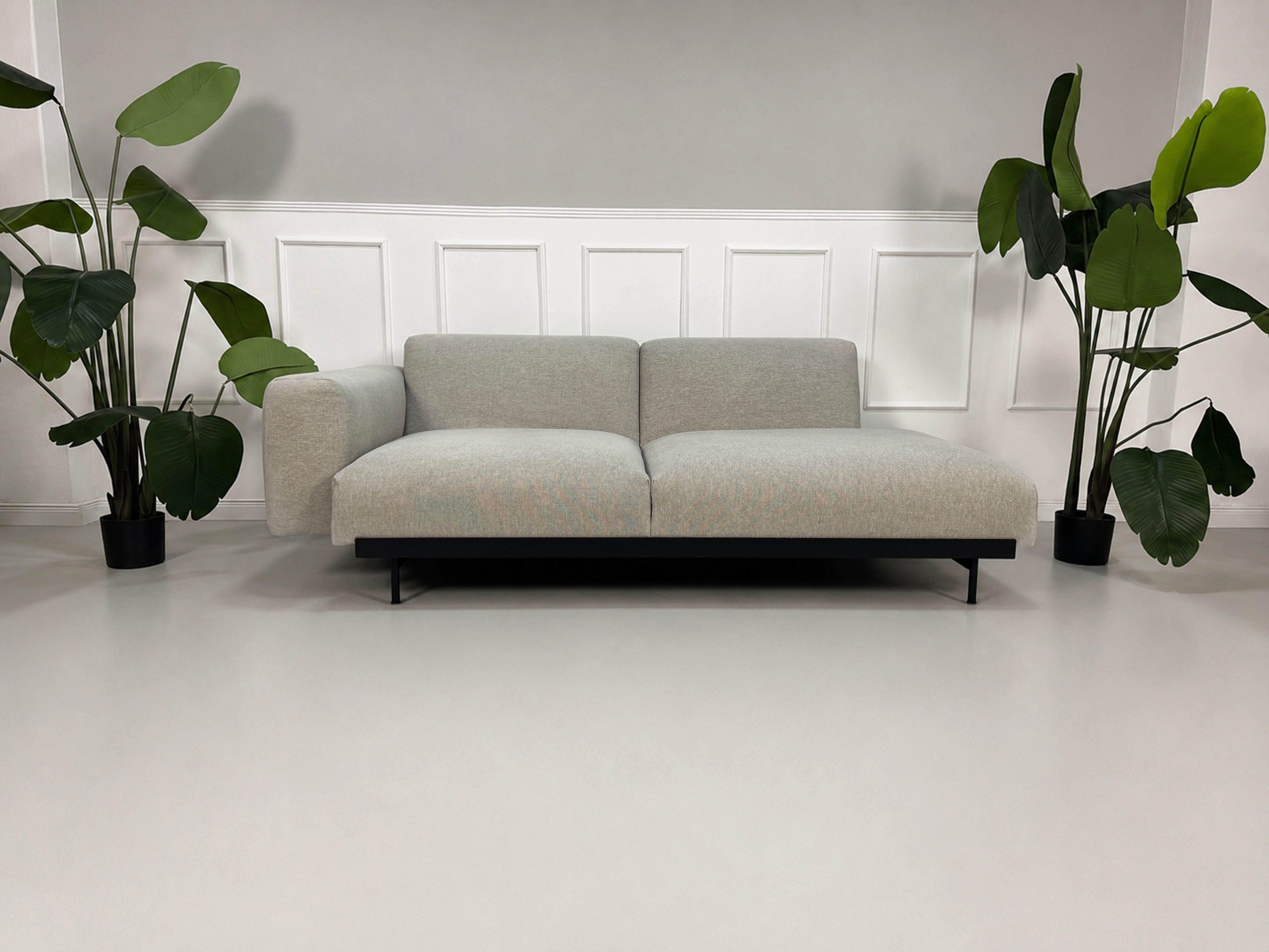 Gebrauchtes grau beiges Muuto In Situ Designer Stoff Sofa vor einer Wand, stilvoll und modern eingerichtet.