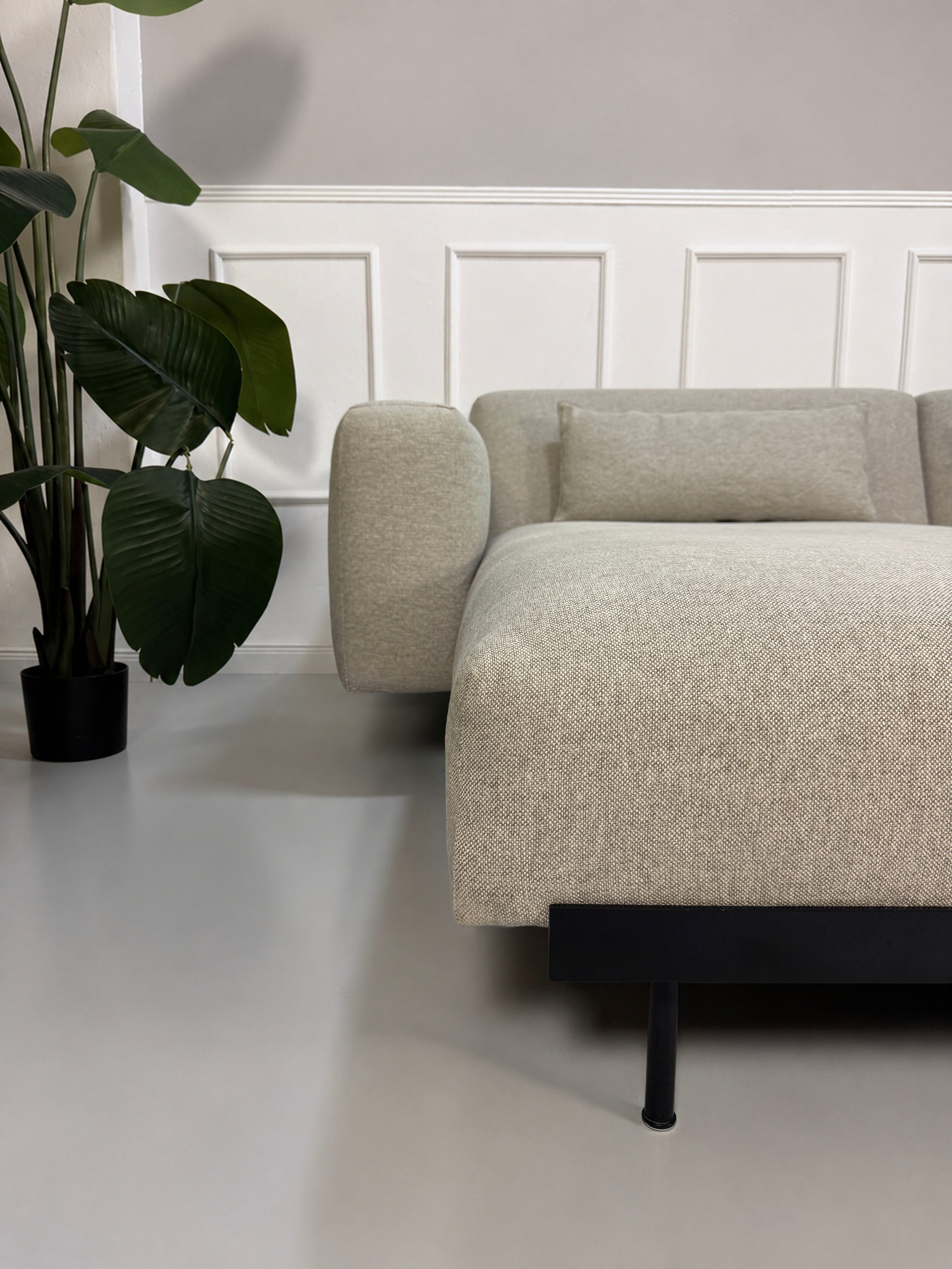 Gebrauchtes grau beiges Muuto In Situ Designer Stoff Sofa vor einer Wand, stilvoll und modern eingerichtet.