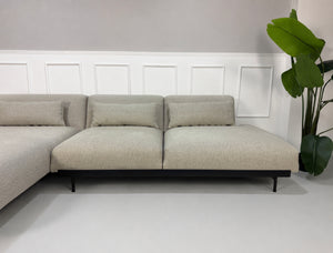 Gebrauchtes grau beiges Muuto In Situ Designer Stoff Sofa vor einer Wand, stilvoll und modern eingerichtet.