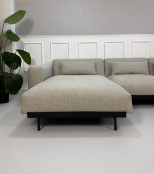 Gebrauchtes grau beiges Muuto In Situ Designer Stoff Sofa vor einer Wand, stilvoll und modern eingerichtet.