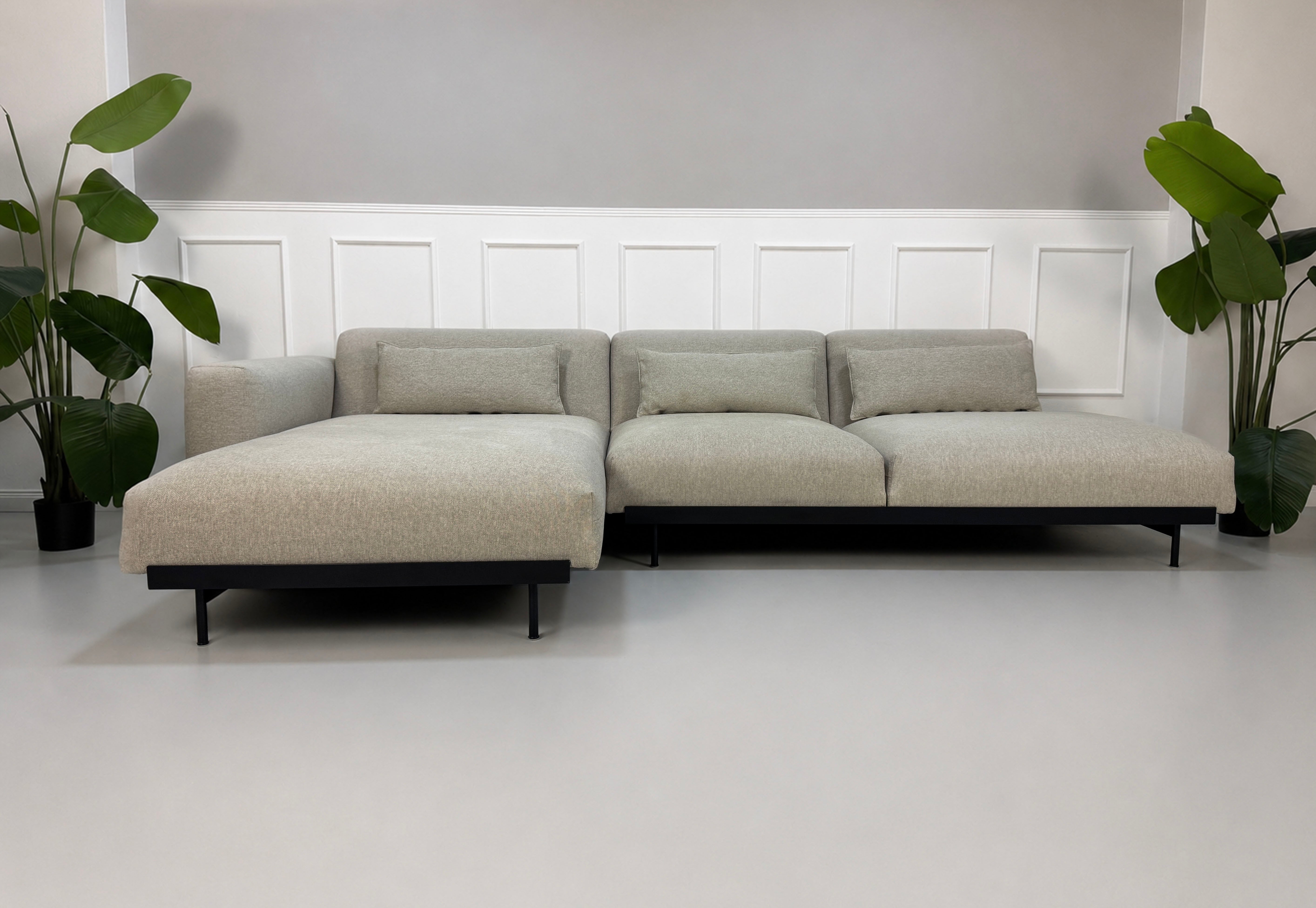 Gebrauchtes grau beiges Muuto In Situ Designer Stoff Sofa vor einer Wand, stilvoll und modern eingerichtet.