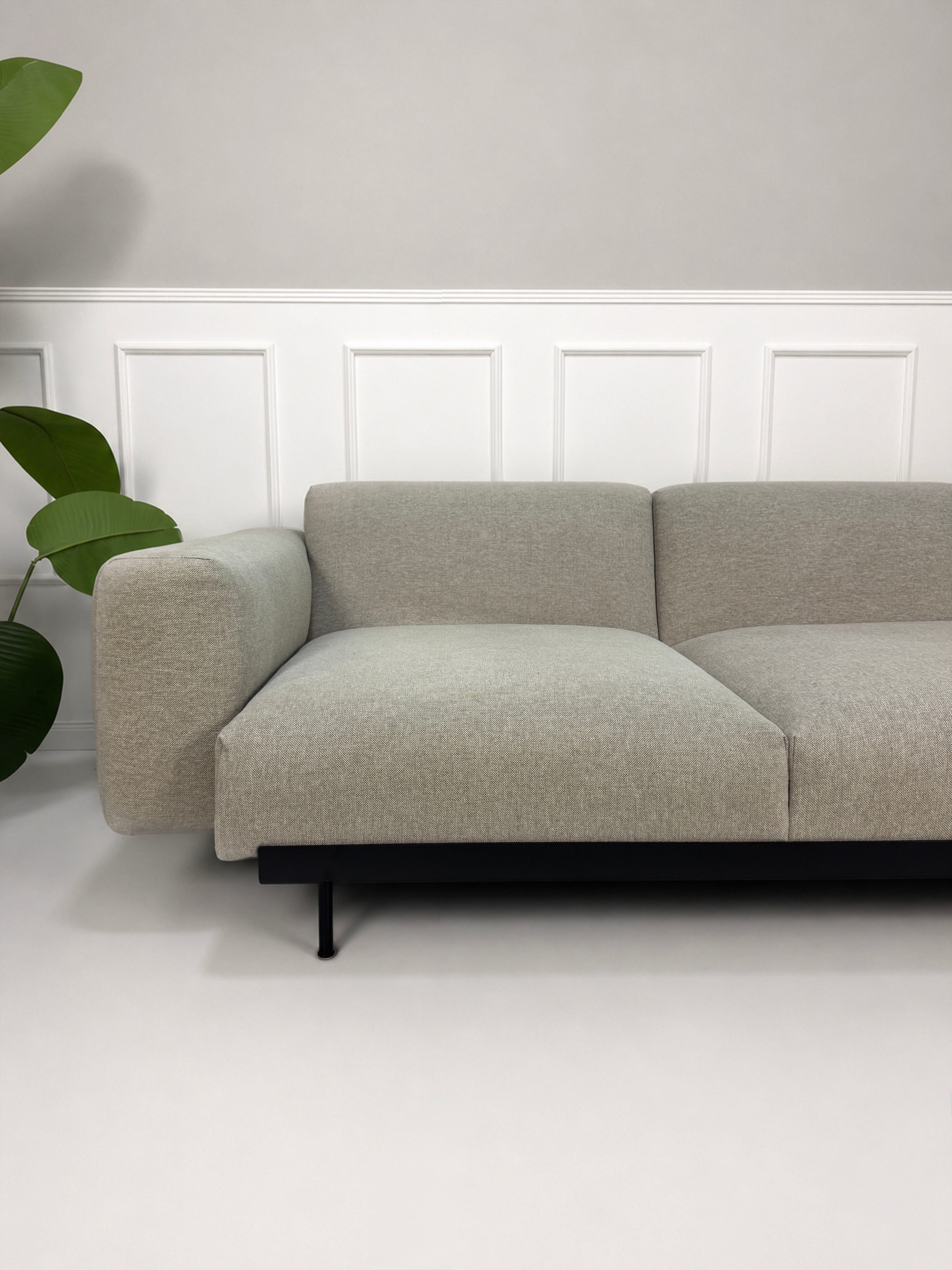 Gebrauchtes grau beiges Muuto In Situ Designer Stoff Sofa vor einer Wand, stilvoll und modern eingerichtet.