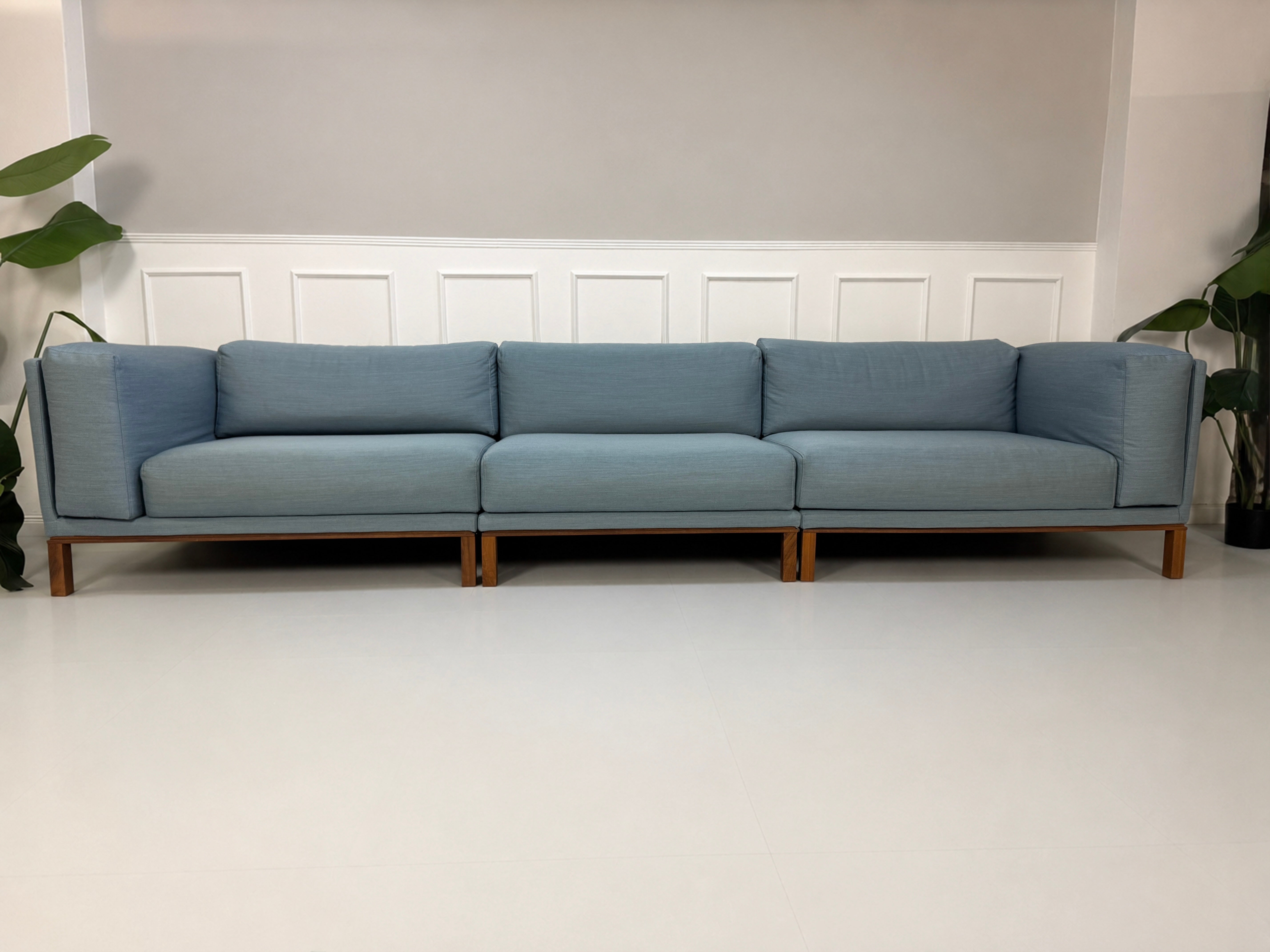 Gebrauchtes blaues Bolia Cosy Designer Stoff Sofa vor einer Wand, stilvoll und modern eingerichtet.
