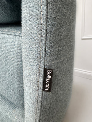 Gebrauchtes blaues Bolia Cosy Designer Stoff Sofa vor einer Wand, stilvoll und modern eingerichtet.