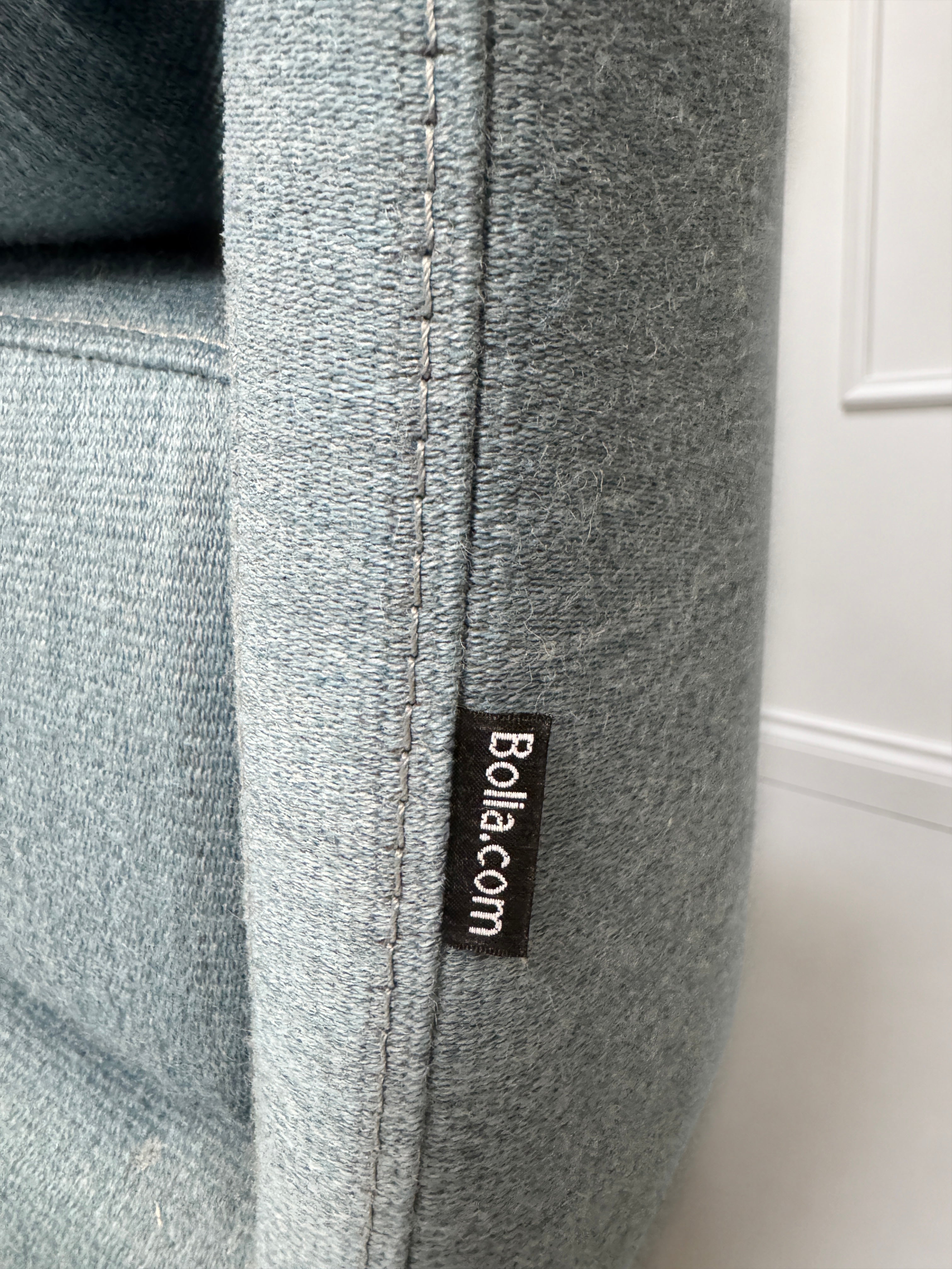 Gebrauchtes blaues Bolia Cosy Designer Stoff Sofa vor einer Wand, stilvoll und modern eingerichtet.