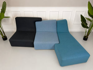 Gebrauchtes blaues Ligne Roset Confluences Designer Stoff Sofa vor einer Wand, stilvoll und modern eingerichtet.