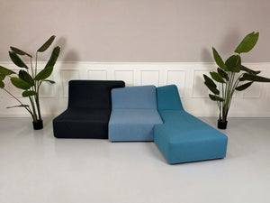 Gebrauchtes blaues Ligne Roset Confluences Designer Stoff Sofa vor einer Wand, stilvoll und modern eingerichtet.