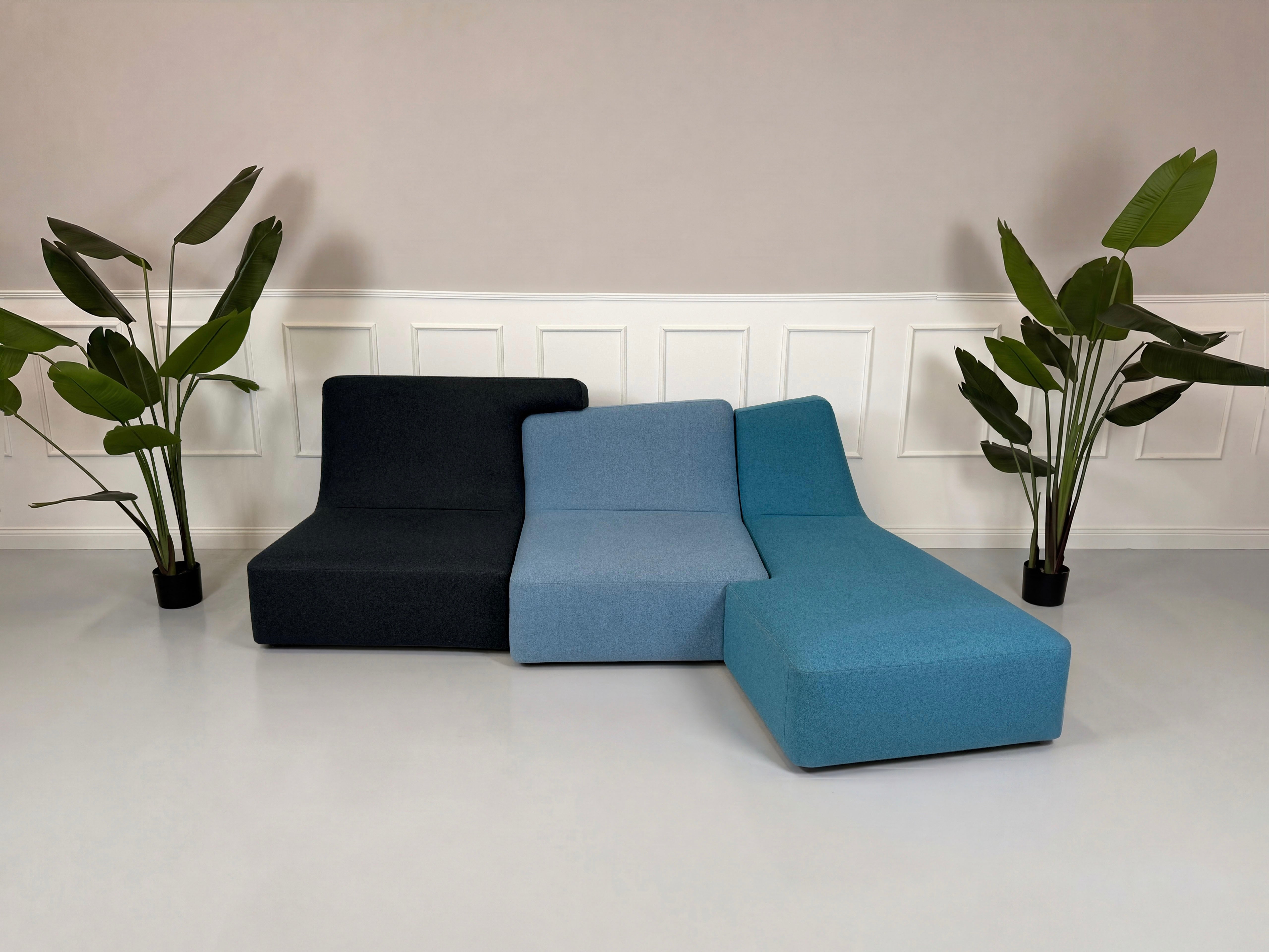 Gebrauchtes blaues Ligne Roset Confluences Designer Stoff Sofa vor einer Wand, stilvoll und modern eingerichtet.