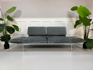 Gebrauchtes graues Brühl Roro medium Designer Stoff Sofa vor einer Wand, stilvoll und modern eingerichtet.