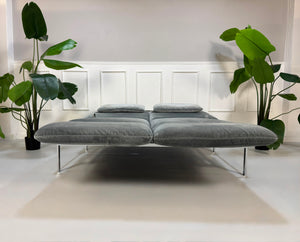 Gebrauchtes graues Brühl Roro medium Designer Stoff Sofa vor einer Wand, stilvoll und modern eingerichtet.