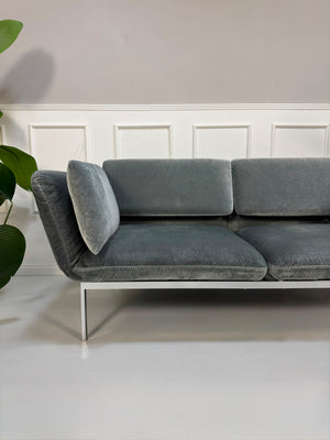 Gebrauchtes graues Brühl Roro medium Designer Stoff Sofa vor einer Wand, stilvoll und modern eingerichtet.