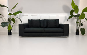 Gebrauchtes graues Minotti Hamilton Designer Stoff Sofa vor einer Wand, stilvoll und modern eingerichtet.