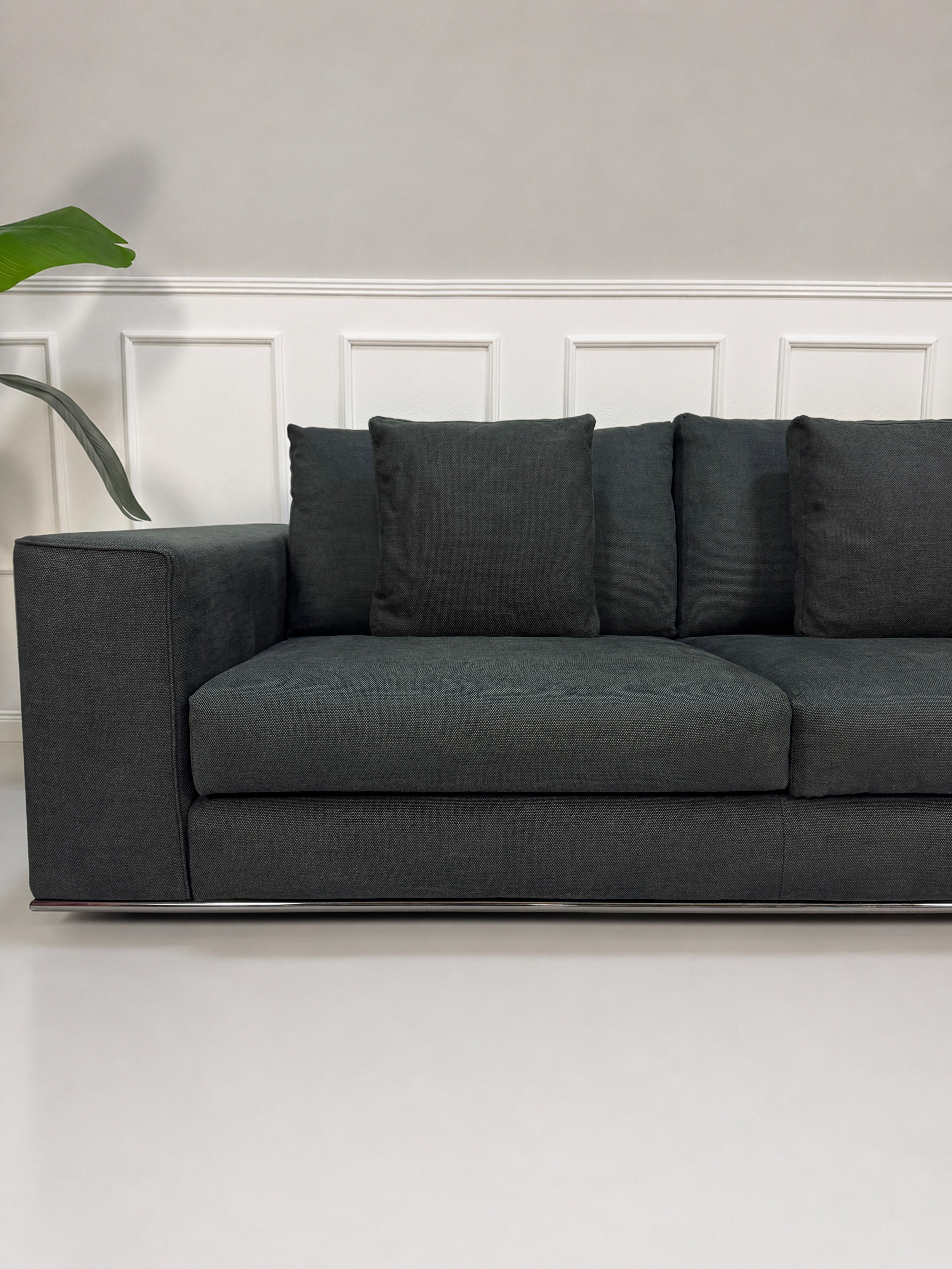 Gebrauchtes graues Minotti Hamilton Designer Stoff Sofa vor einer Wand, stilvoll und modern eingerichtet.