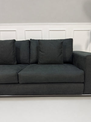 Gebrauchtes graues Minotti Hamilton Designer Stoff Sofa vor einer Wand, stilvoll und modern eingerichtet.