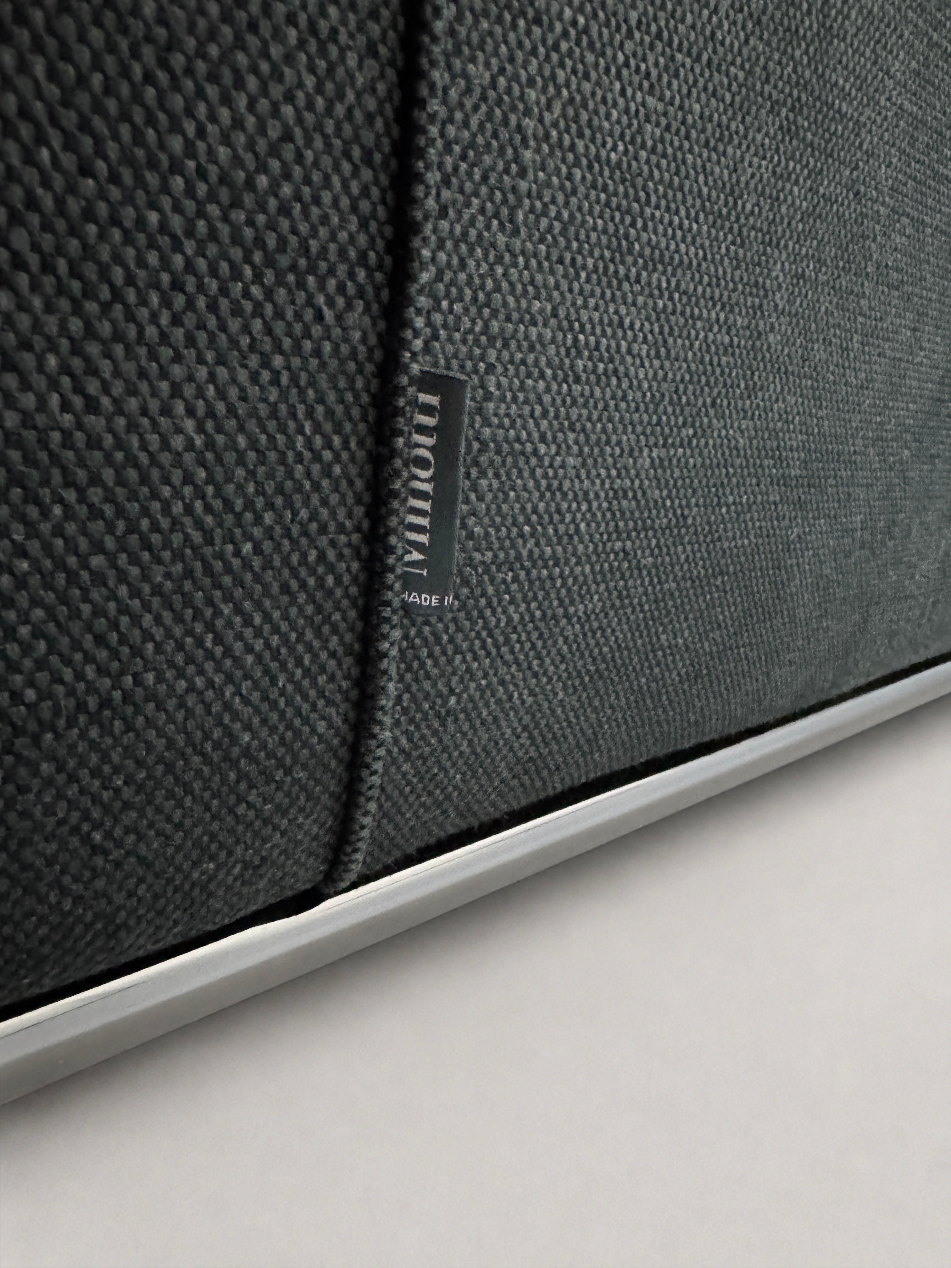 Gebrauchtes graues Minotti Hamilton Designer Stoff Sofa vor einer Wand, stilvoll und modern eingerichtet.