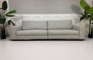 Ausstellungsstück graues Minotti Hamilton Designer Stoff Sofa vor einer Wand, stilvoll und modern eingerichtet.