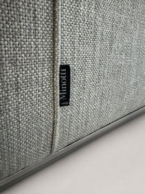 Ausstellungsstück graues Minotti Hamilton Designer Stoff Sofa vor einer Wand, stilvoll und modern eingerichtet.