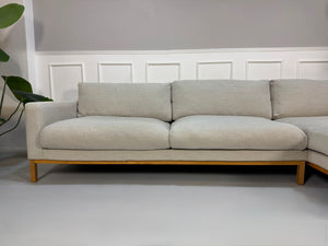Gebrauchtes beiges Bolia North Designer Stoff Sofa vor einer Wand, stilvoll und modern eingerichtet.