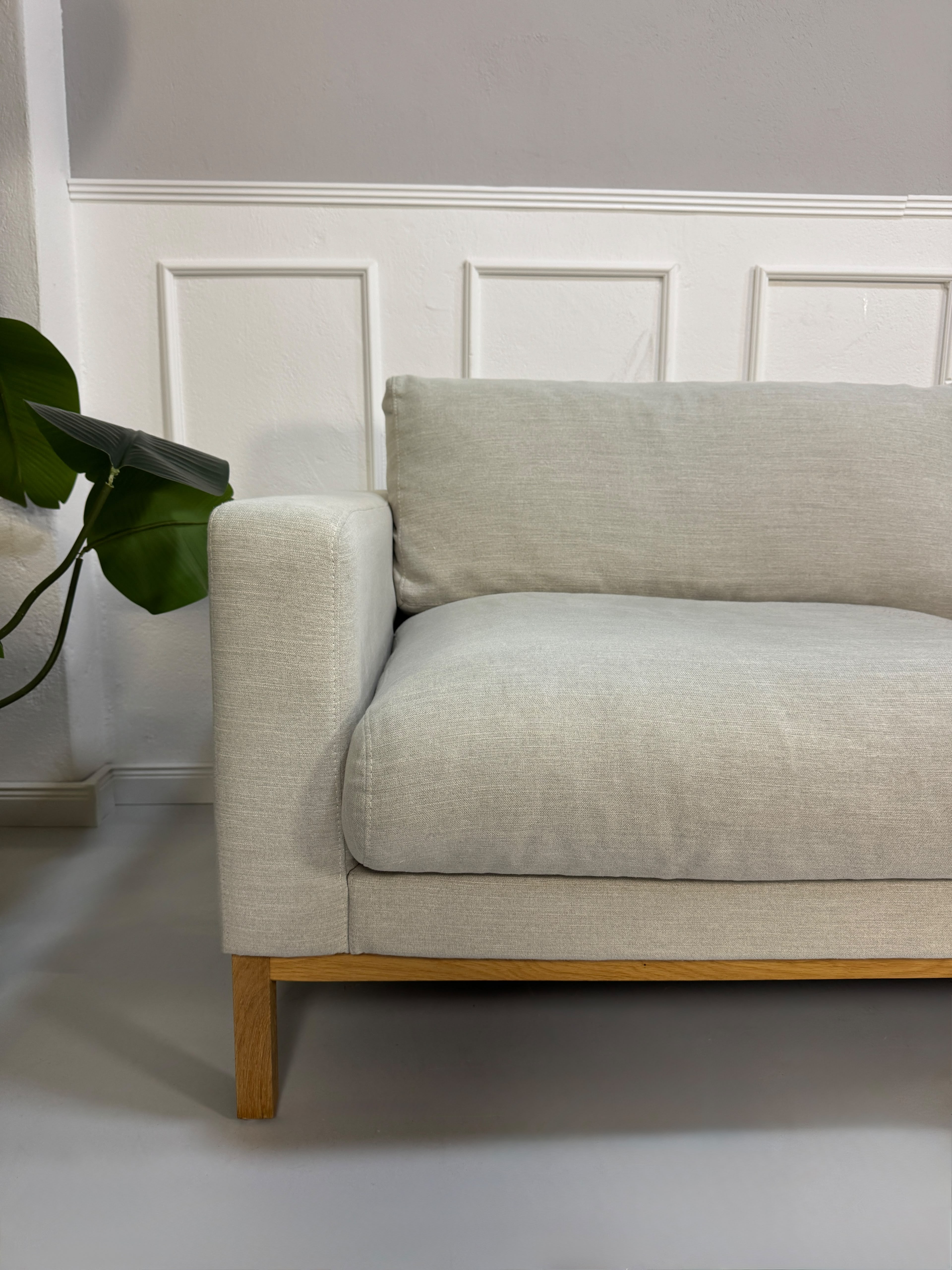 Gebrauchtes beiges Bolia North Designer Stoff Sofa vor einer Wand, stilvoll und modern eingerichtet.