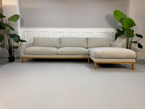 Gebrauchtes beiges Bolia North Designer Stoff Sofa vor einer Wand, stilvoll und modern eingerichtet.