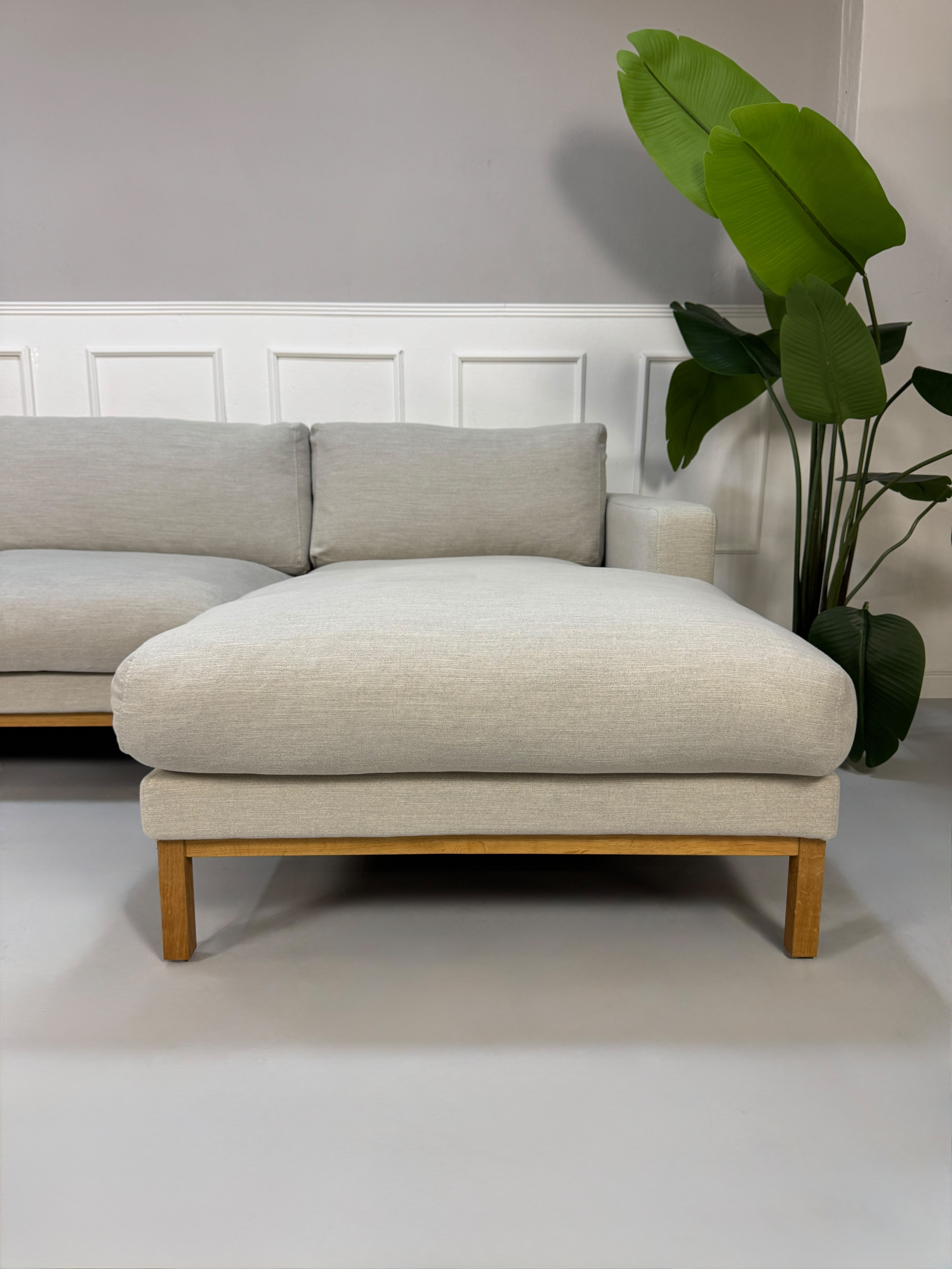Gebrauchtes beiges Bolia North Designer Stoff Sofa vor einer Wand, stilvoll und modern eingerichtet.