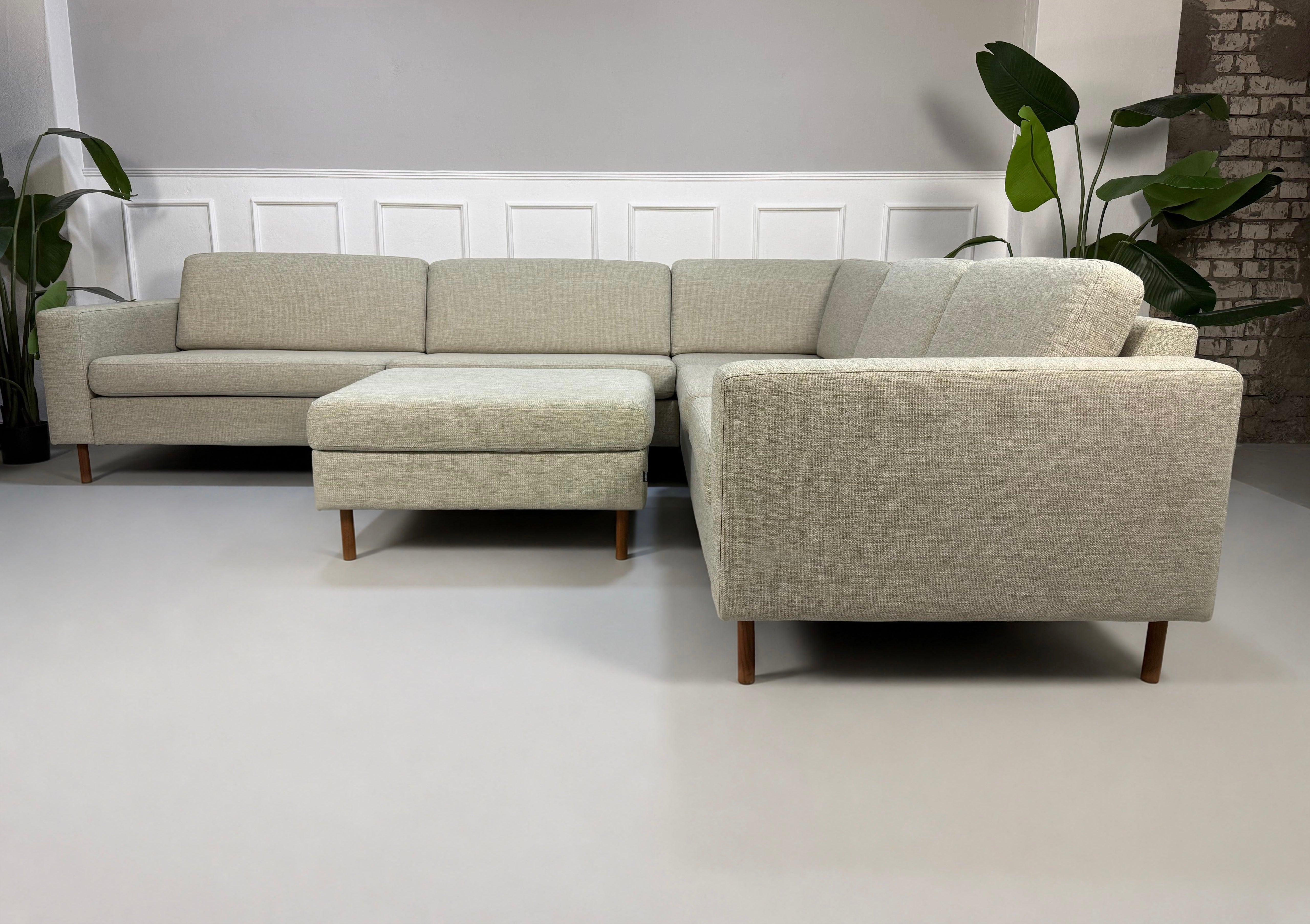 Gebrauchtes beiges Bolia Scandinavia 6 Sitzer Designer Stoff Sofa vor einer Wand, stilvoll und modern eingerichtet.