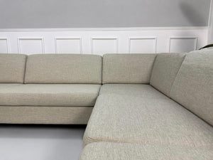 Gebrauchtes beiges Bolia Scandinavia 6 Sitzer Designer Stoff Sofa vor einer Wand, stilvoll und modern eingerichtet.