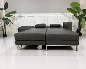 Ausstellungsstück Brühl Four Two  Designer Leder Sofa vor einer Wand, stilvoll und modern eingerichtet.