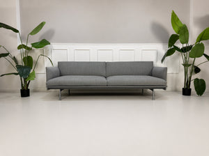 Gebrauchtes graues Muuto Outline Designer Stoff Sofa vor einer Wand, stilvoll und modern eingerichtet.