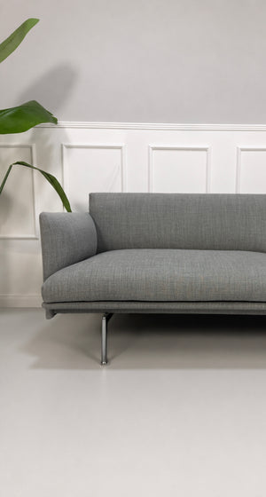 Gebrauchtes graues Muuto Outline Designer Stoff Sofa vor einer Wand, stilvoll und modern eingerichtet.