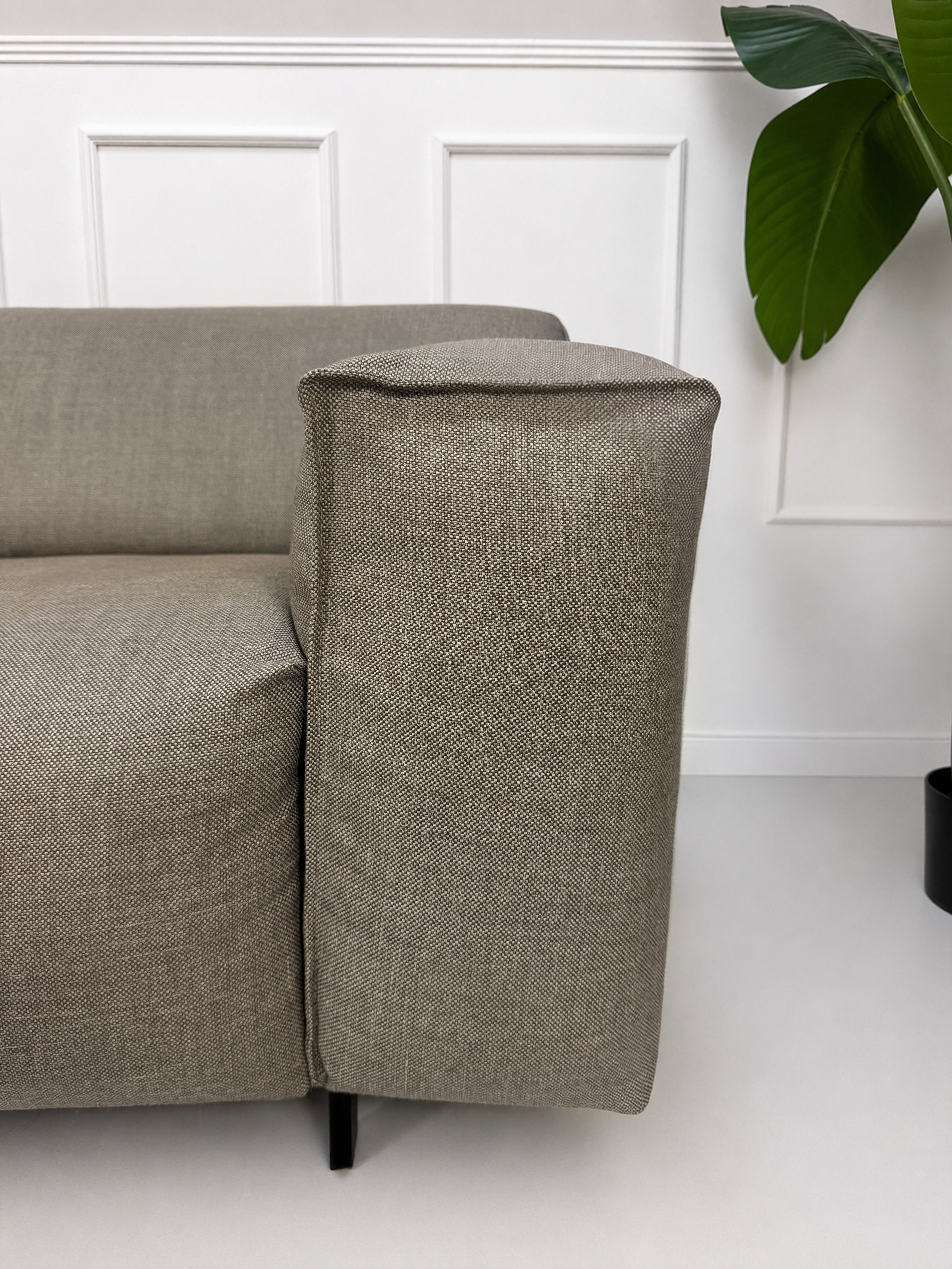 Gebrauchtes graues Rolf Benz Grata Designer Stoff Sofa mit Hocker vor einer Wand, stilvoll und modern eingerichtet.