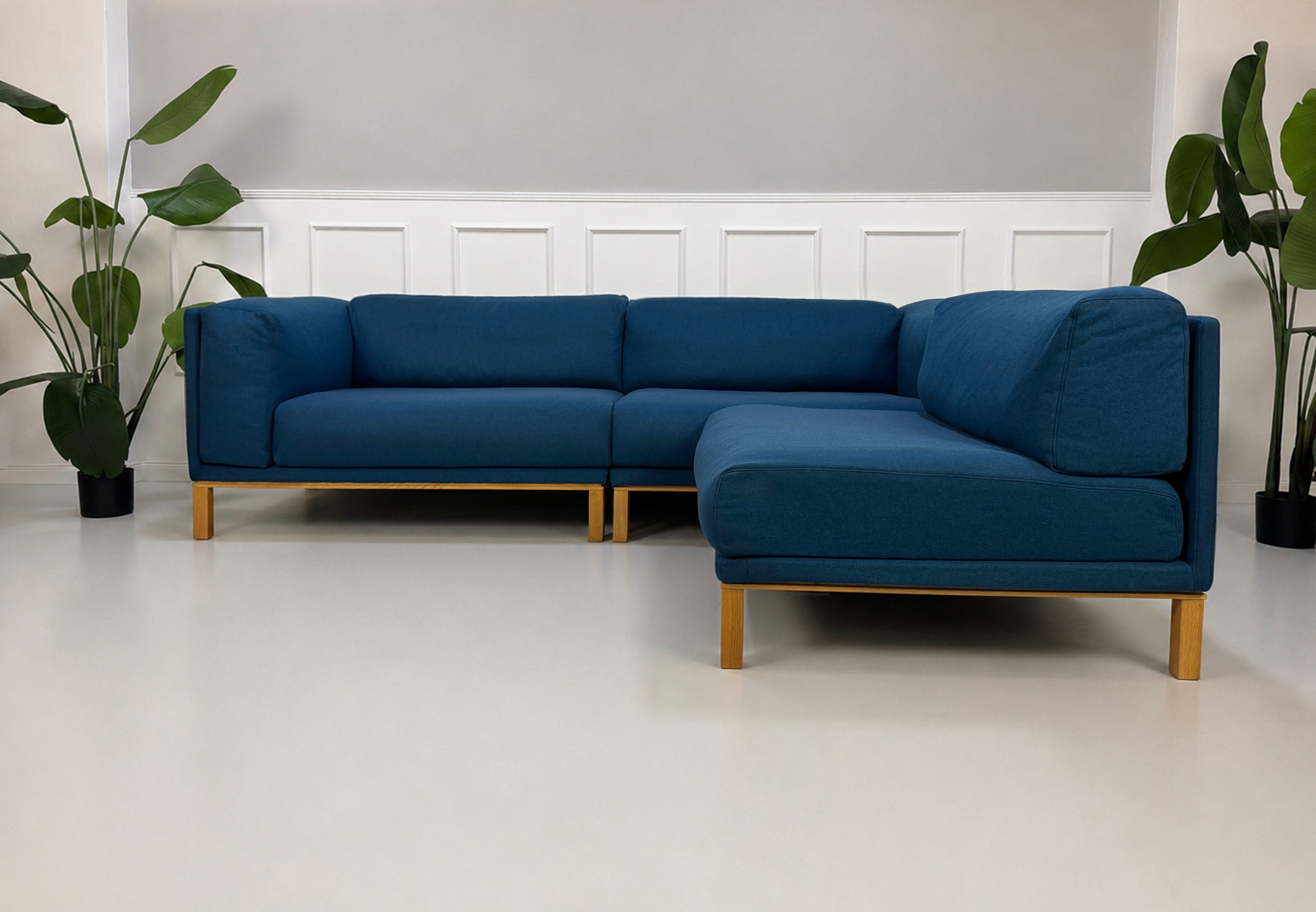 Gebrauchtes blaues Bolia Cosy Designer Stoff Sofa vor einer Wand, stilvoll und modern eingerichtet.