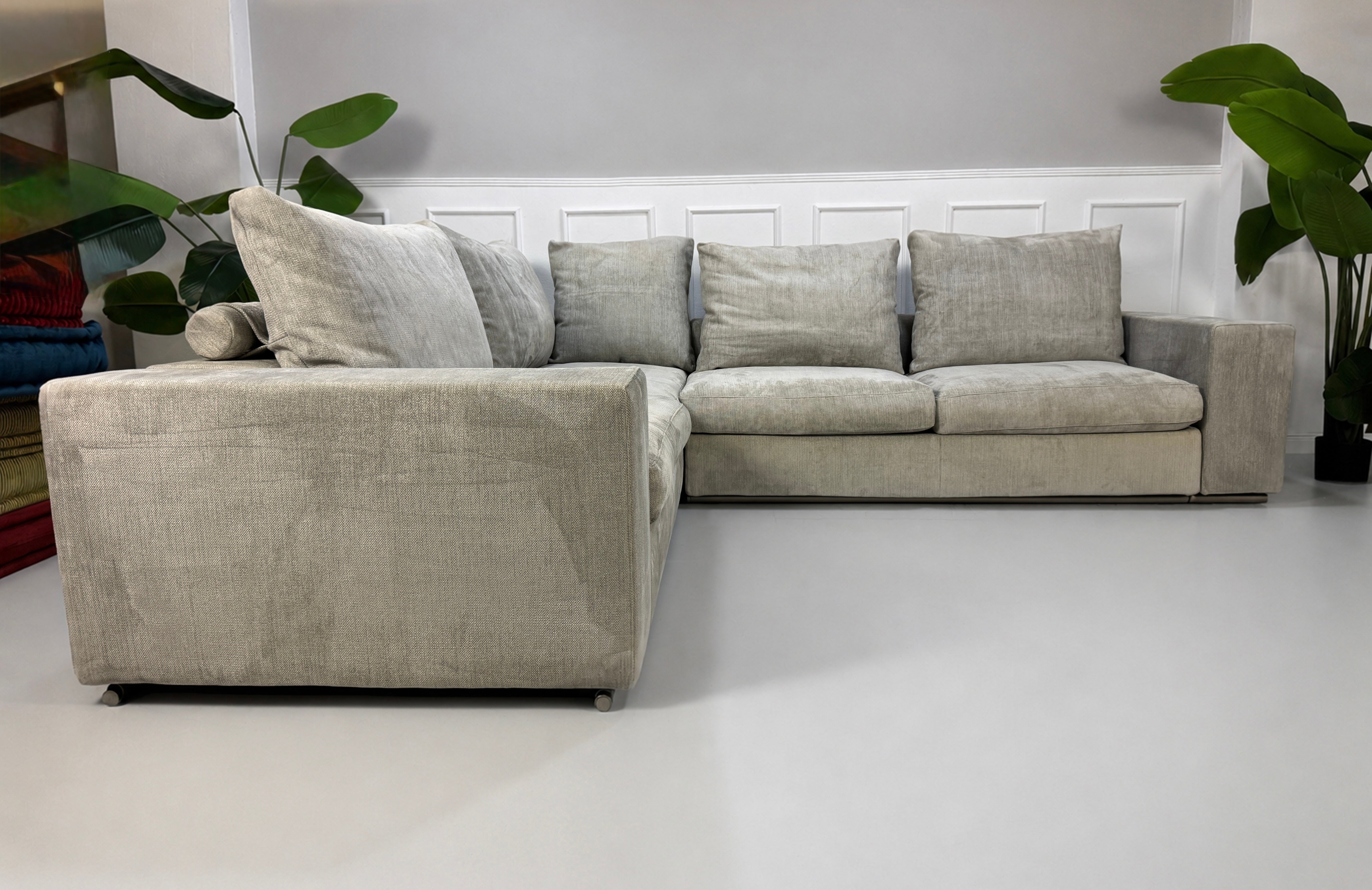 Gebrauchtes graues Flexform Groundpiece Designer Stoff Sofa vor einer Wand, stilvoll und modern eingerichtet.
