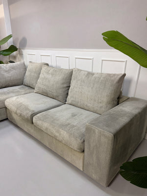 Gebrauchtes graues Flexform Groundpiece Designer Stoff Sofa vor einer Wand, stilvoll und modern eingerichtet.