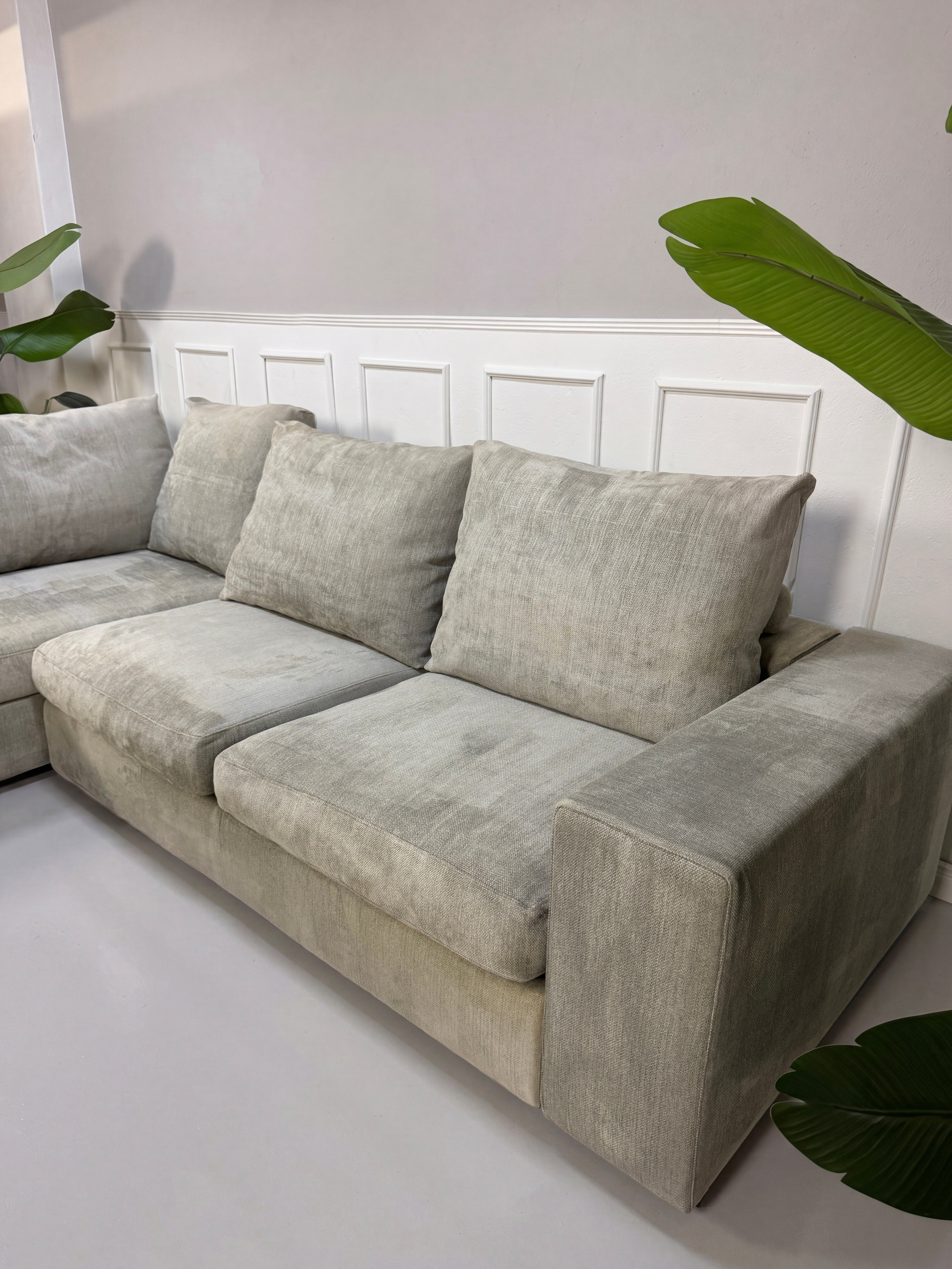 Gebrauchtes graues Flexform Groundpiece Designer Stoff Sofa vor einer Wand, stilvoll und modern eingerichtet.