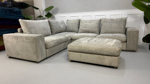 Gebrauchtes graues Flexform Groundpiece Designer Stoff Sofa vor einer Wand, stilvoll und modern eingerichtet.