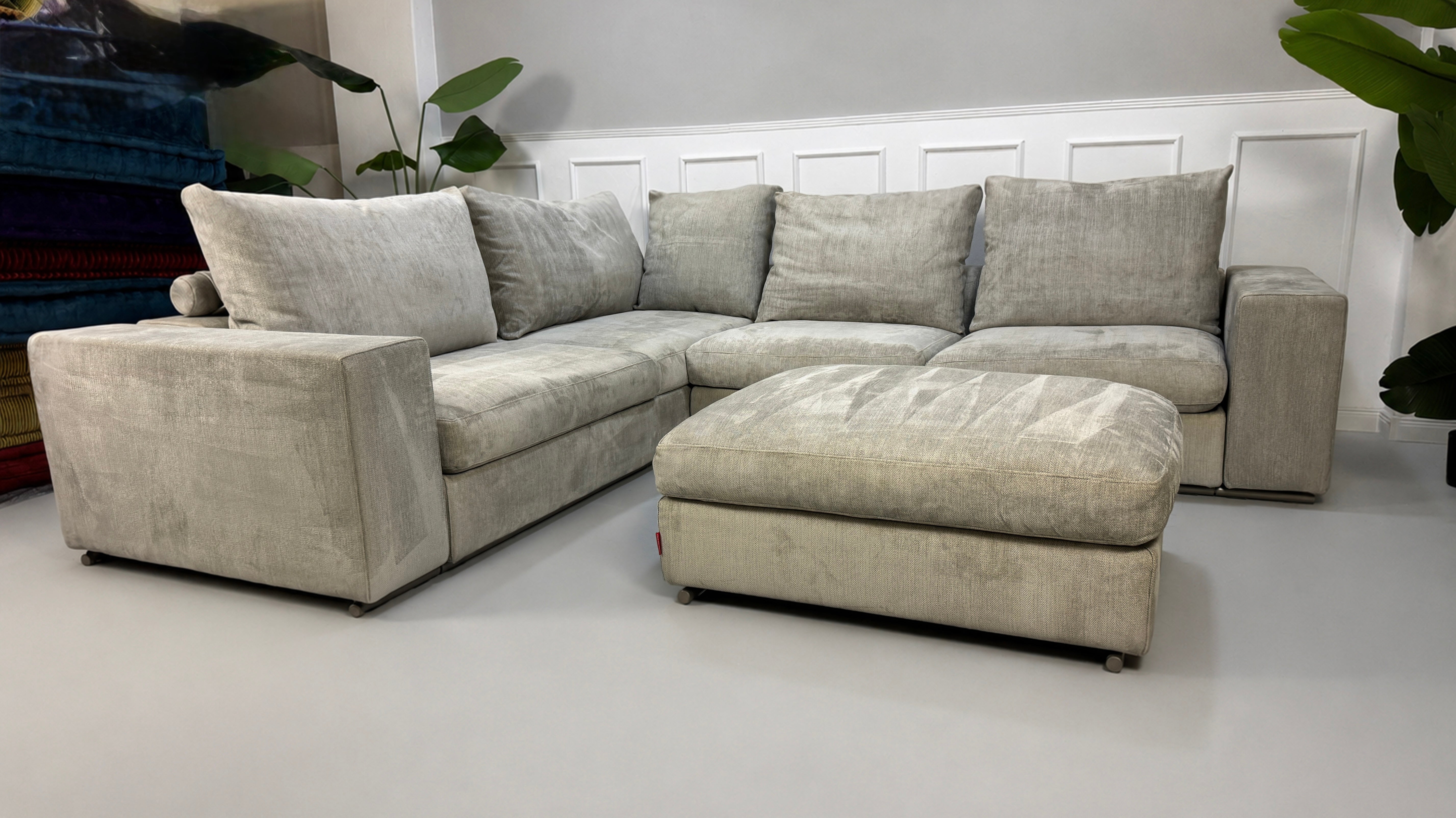 Gebrauchtes graues Flexform Groundpiece Designer Stoff Sofa vor einer Wand, stilvoll und modern eingerichtet.