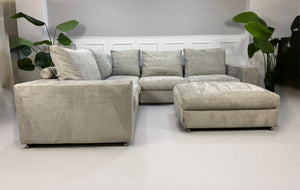 Gebrauchtes graues Flexform Groundpiece Designer Stoff Sofa vor einer Wand, stilvoll und modern eingerichtet.