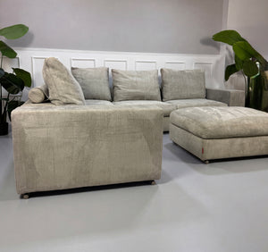 Gebrauchtes graues Flexform Groundpiece Designer Stoff Sofa vor einer Wand, stilvoll und modern eingerichtet.