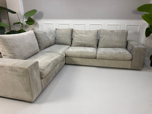 Gebrauchtes graues Flexform Groundpiece Designer Stoff Sofa vor einer Wand, stilvoll und modern eingerichtet.