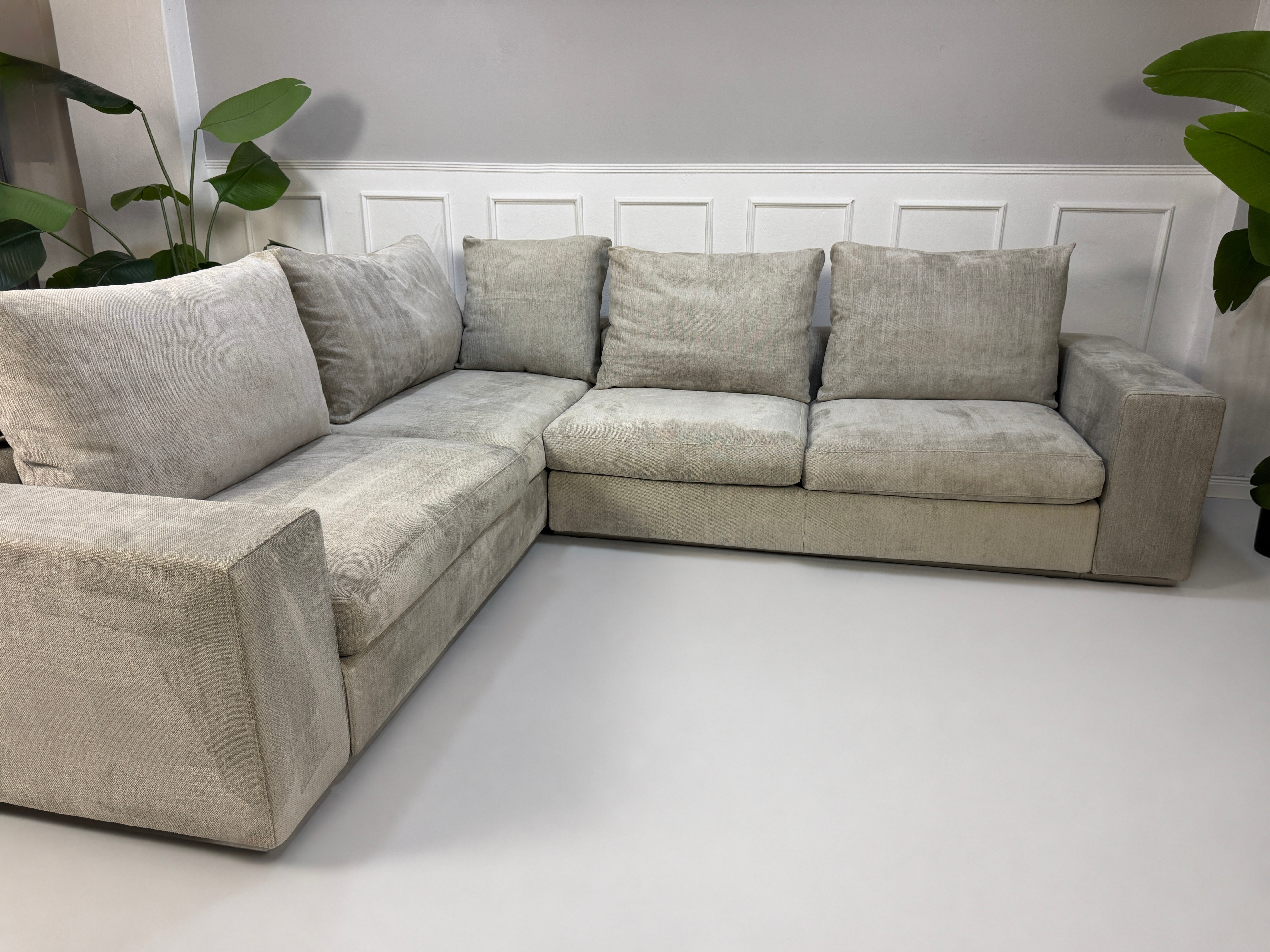Gebrauchtes graues Flexform Groundpiece Designer Stoff Sofa vor einer Wand, stilvoll und modern eingerichtet.