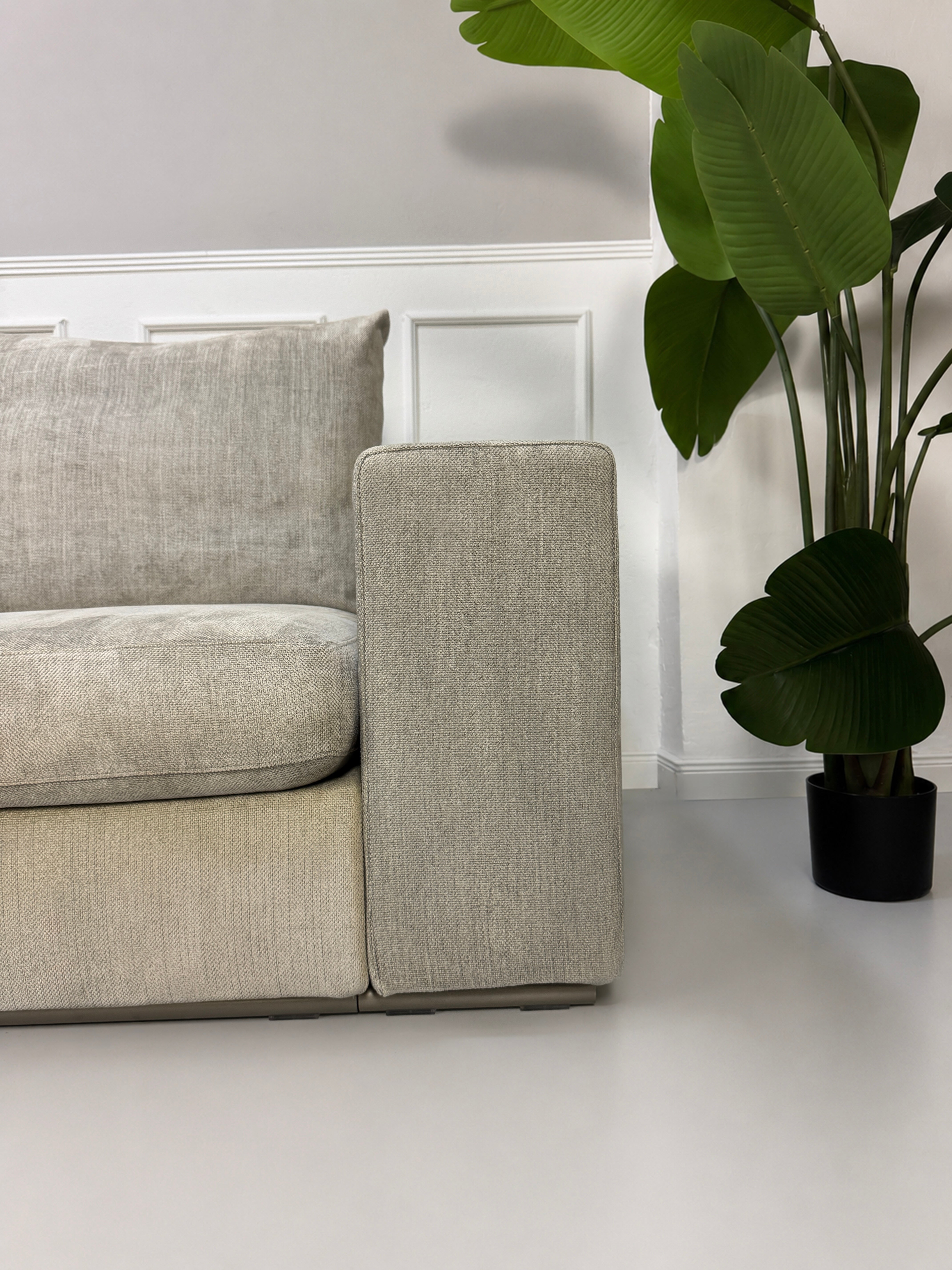 Gebrauchtes graues Flexform Groundpiece Designer Stoff Sofa vor einer Wand, stilvoll und modern eingerichtet.