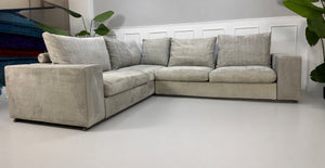 Gebrauchtes graues Flexform Groundpiece Designer Stoff Sofa vor einer Wand, stilvoll und modern eingerichtet.