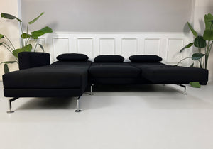 Gebrauchtes schwarzes Brühl Moule Designer Stoff Sofa vor einer Wand, stilvoll und modern eingerichtet.